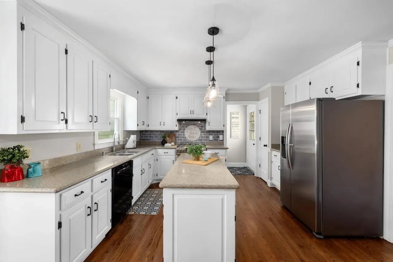 Kitchen with white cabinets, an island, and stainless steel appliances