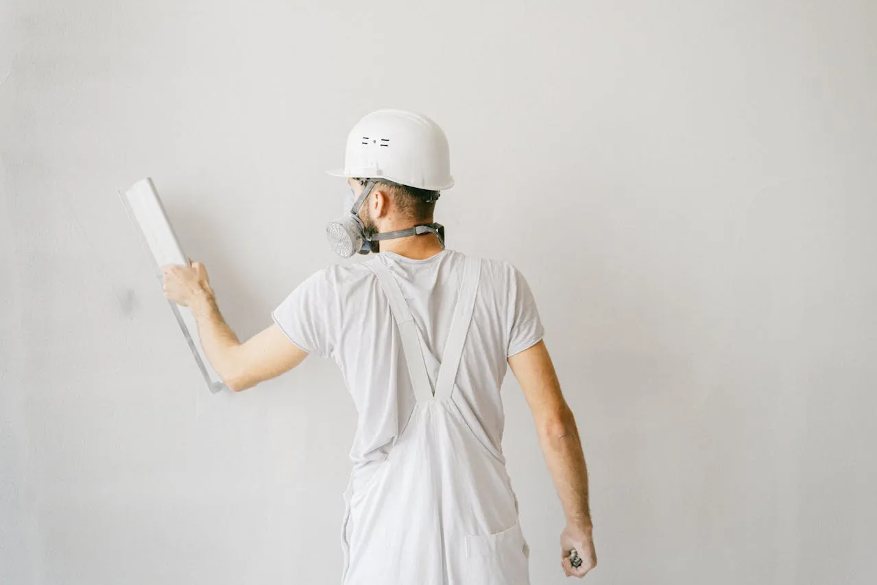 A worker smoothing an interior wall surface